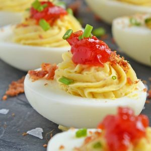 Close up of tomato jam deviled eggs on a slate