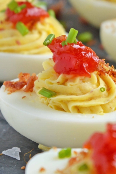 Close up of tomato jam deviled eggs on a slate