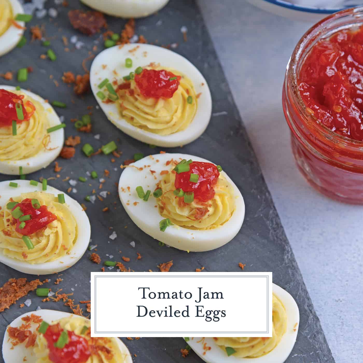 Tomato Jam Deviled Eggs use sweet tomato jam with tangy horseradish in a devilishly creamy deviled egg filling. Top with chives and serve! #deviledeggs www.savoryexperiments.com