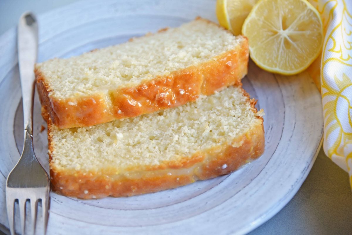 Yogurt, fresh lemon and almond give this sunny loaf cake a unique flavor and texture that everyone will love. Perfect for brunch, tea or dessert! #loafcake #lemoncake #almondcake www.savoryexperiments.com