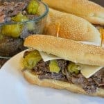 Slow Cooker Italian Beef Hoagies are tender beef with moderately hot pepperoncini chiles, smothered with cheese and loaded onto a hearty roll. | #slowcookermeals | www.savoryexperiments.com