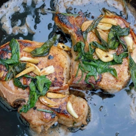 Butter Sage Pork Chop Recipe- Crispy sage and garlic top succulent thick cut bone-in pork chops prepared in cast iron. | #castironcooking | www.savoryexperiments.com