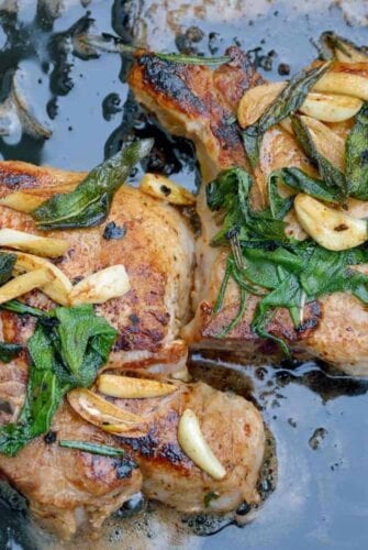 Butter Sage Pork Chop Recipe- Crispy sage and garlic top succulent thick cut bone-in pork chops prepared in cast iron. | #castironcooking | www.savoryexperiments.com
