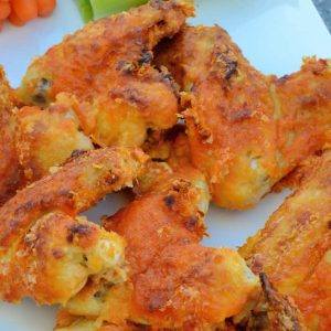Crispy Baked Buffalo Wings uses a secret ingredient to "bread" wings. Bake to crispy perfection and toss in a garlic buffalo sauce. #bakedbuffalowings #crispychickenwings www.savoryexperiments.com