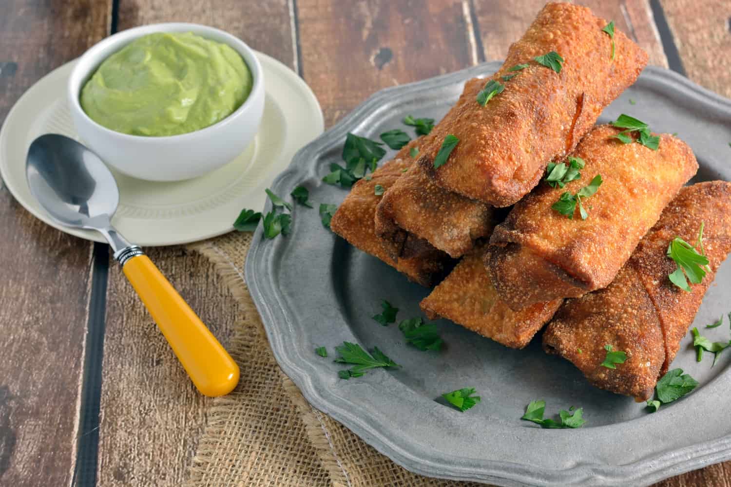 Pulled Pork and Smoked Gouda Egg Rolls Recipe - Succulent, sweet and zesty pulled pork wrapped in a crispy egg roll with silky smoked gouda cheese and served alongside Avocado Green Goddess Dressing. 