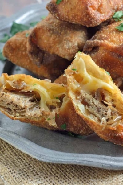 Pull Pork and Smoked Gouda Egg Rolls Recipe - Succulent, sweet and zesty pulled pork wrapped in a crispy egg roll with silky smoked gouda cheese and served alongside Avocado Green Goddess Dressing.