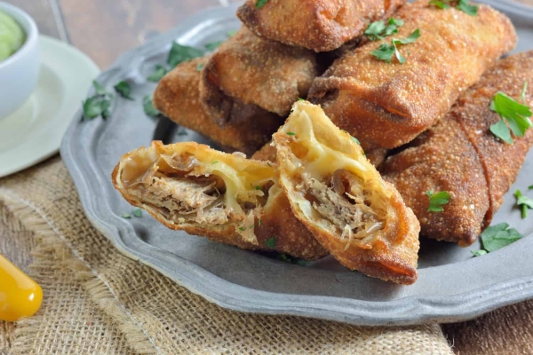 Pull Pork and Smoked Gouda Egg Rolls Recipe Pull Pork and Smoked Gouda Egg Rolls Recipe - Succulent, sweet and zesty pulled pork wrapped in a crispy egg roll with silky smoked gouda cheese and served alongside Avocado Green Goddess Dressing.