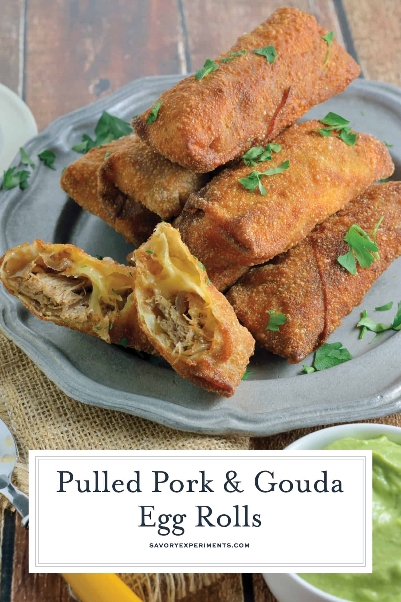Pulled Pork and Gouda Egg Rolls are succulent, sweet and zesty pulled pork wrapped in a crispy egg roll with silky smoked gouda cheese and served alongside Avocado Green Goddess Dressing. #homemadeeggrolls www.savoryexperiments.com