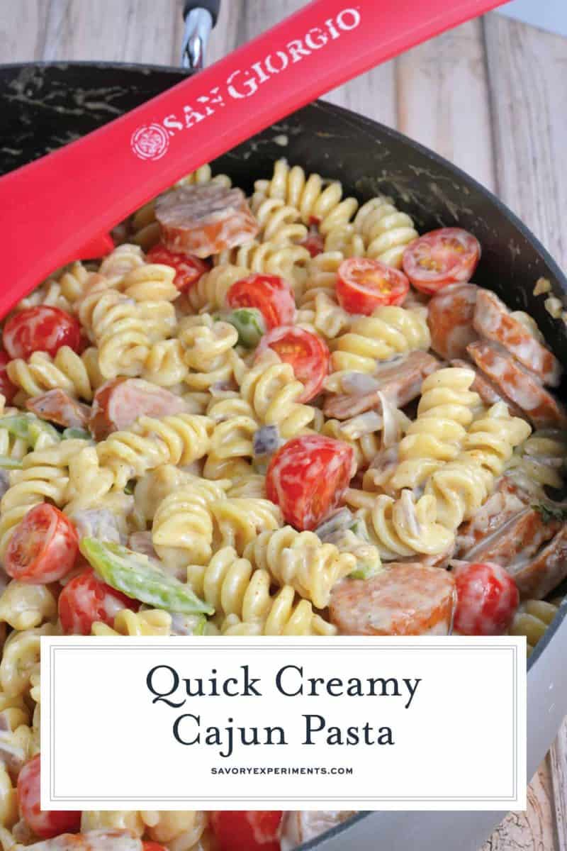 Creamy Cajun Pasta is rotini in a cream sauce with cajun seasoning, smoky andouille sausage, sautéed peppers, red onion and grape tomatoes. Takes 20 minutes to make! #cajunpasta #easypastadishes www.savoryexperiments.com
