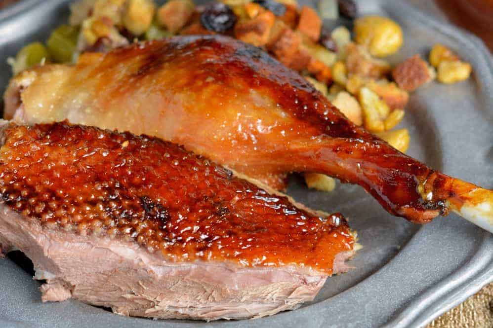 Sweet Roasted Goose is a tried and true recipe for a succulent goose with crispy skin and tender meat seasoned with apple, orange and potato stuffing. Top with Cumberland Sauce. #howtocookgoose #roastgoose www.savoryexperiments.com