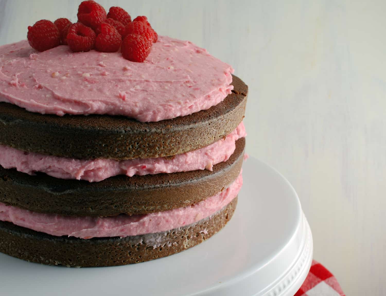 Chocolate Cake with Raspberry Buttercream- "naked cakes" are all the rage and so simple! Moist, rich, and delicious dark chocolate cake that's perfect for Valentine's Day!