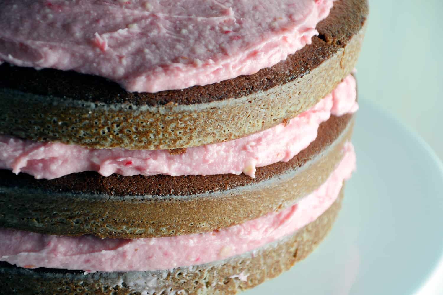 Chocolate Cake with Raspberry Buttercream- "naked cakes" are all the rage and so simple! Moist, rich, and delicious dark chocolate cake that's perfect for Valentine's Day!