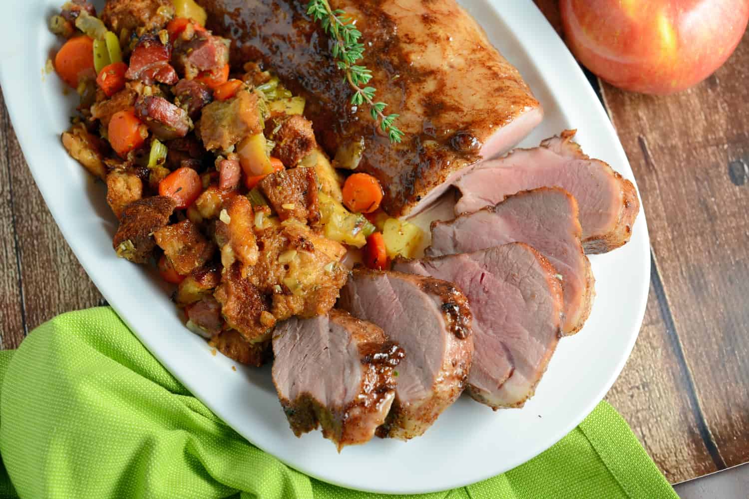 Apple Spiced Pork Tenderloin with Stuffing- one of the best pork recipes out there! This pork tenderloin recipe will blow you away with aromatic spices and an apple jelly glaze, surrounding with fresh apple and ham stuffing, all cooked on the same baking sheet. www.savoryexperiments.com