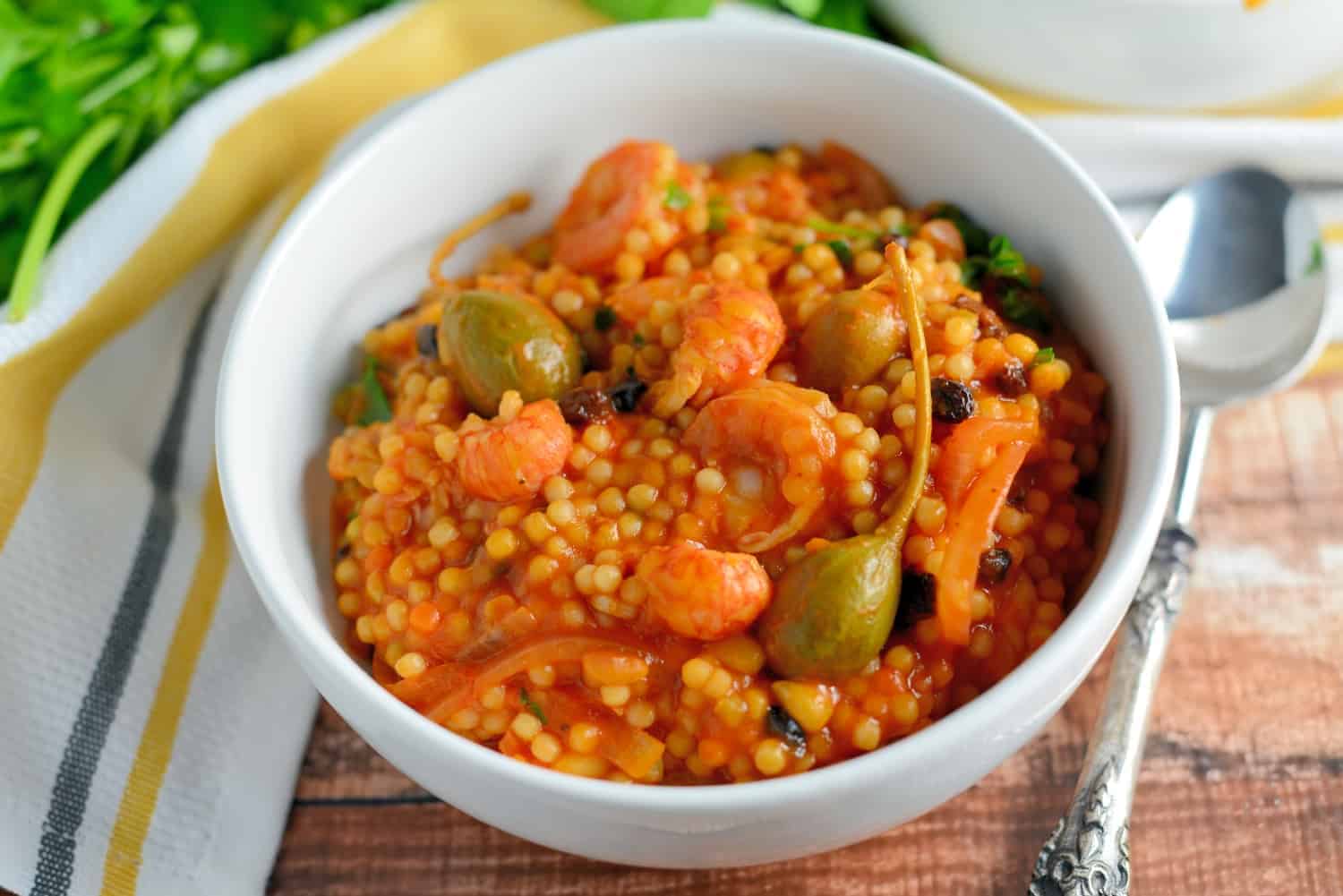 Italian Seafood Stew is a quick seafood recipe using couscous, tomatoes, currants and caper berries. This Italian stew comes together in just 20 minutes from start to finish! #italianseafoodstew #italianstew www.savoryexperiments.com