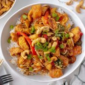 white bowl of cashew chicken over white rice