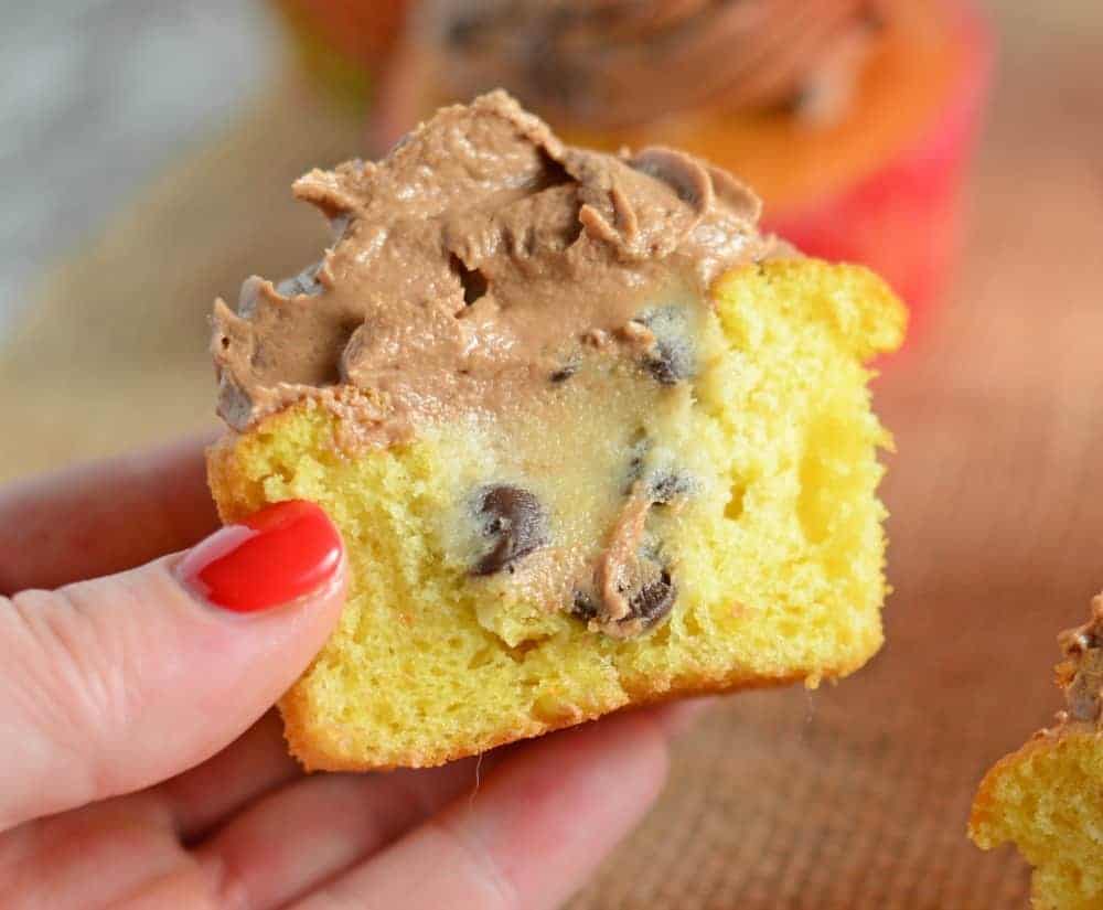 Cookie Dough Stuffed Cupcakes cut in half and topped with chocolate frosting