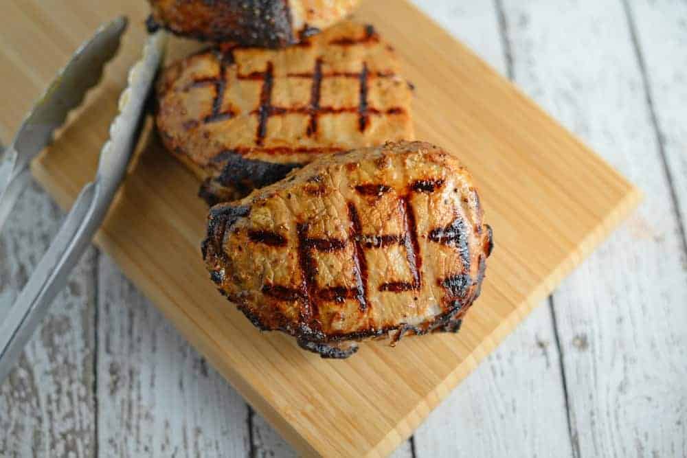 Grilled Dijon Pork Chops are a favorite for pork on the grill. A zesty and easy pork marinade recipes perfect for grilled or baked pork chops! #porkchopsonthegrill #grilledpork www.savoryexperiments.com 