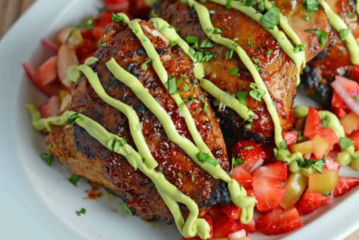 Strawberry BBQ Chicken is a unique take on your classic BBQ Chicken recipe! Tangy strawberry BBQ Sauce pairs with fresh Strawberry Salsa and a cooling avocado cream sauce. #BBQchicken #strawberryBBQsauce www.savoryexperiments.com 