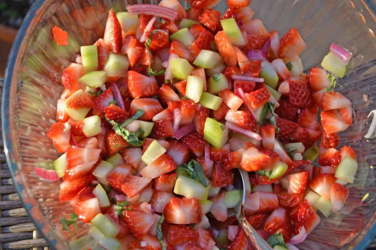 This Strawberry Salsa recipe uses sweet strawberries with cooling cucumber, red onion, basil and zesty white wine vinegar for a juicy dip or condiment. #homemadesalsa #fruitsalsa #strawberrysalsa www.savoryexperiments.com
