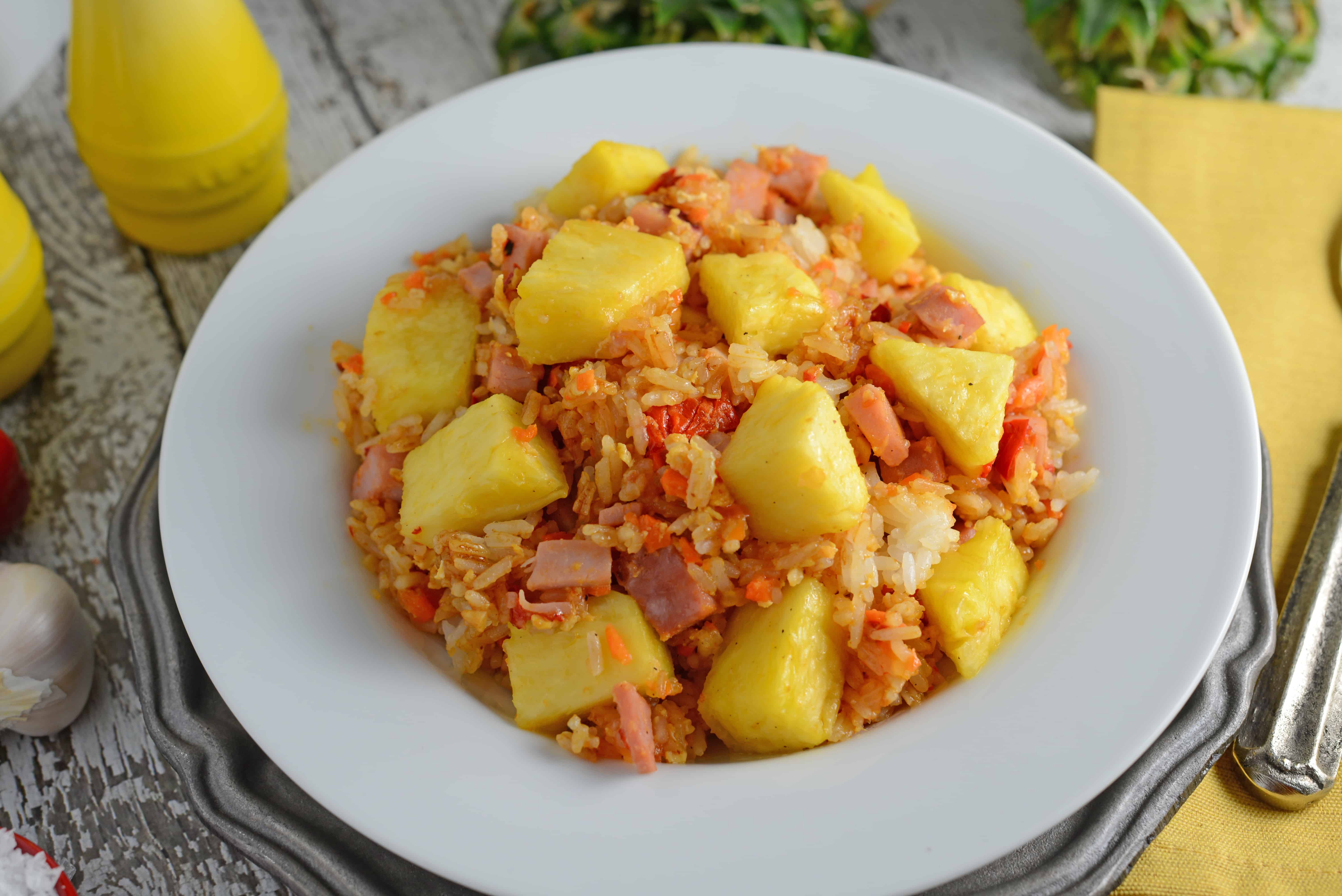 angle bowl of pineapple fried rice with pieces of pineapple and ham 