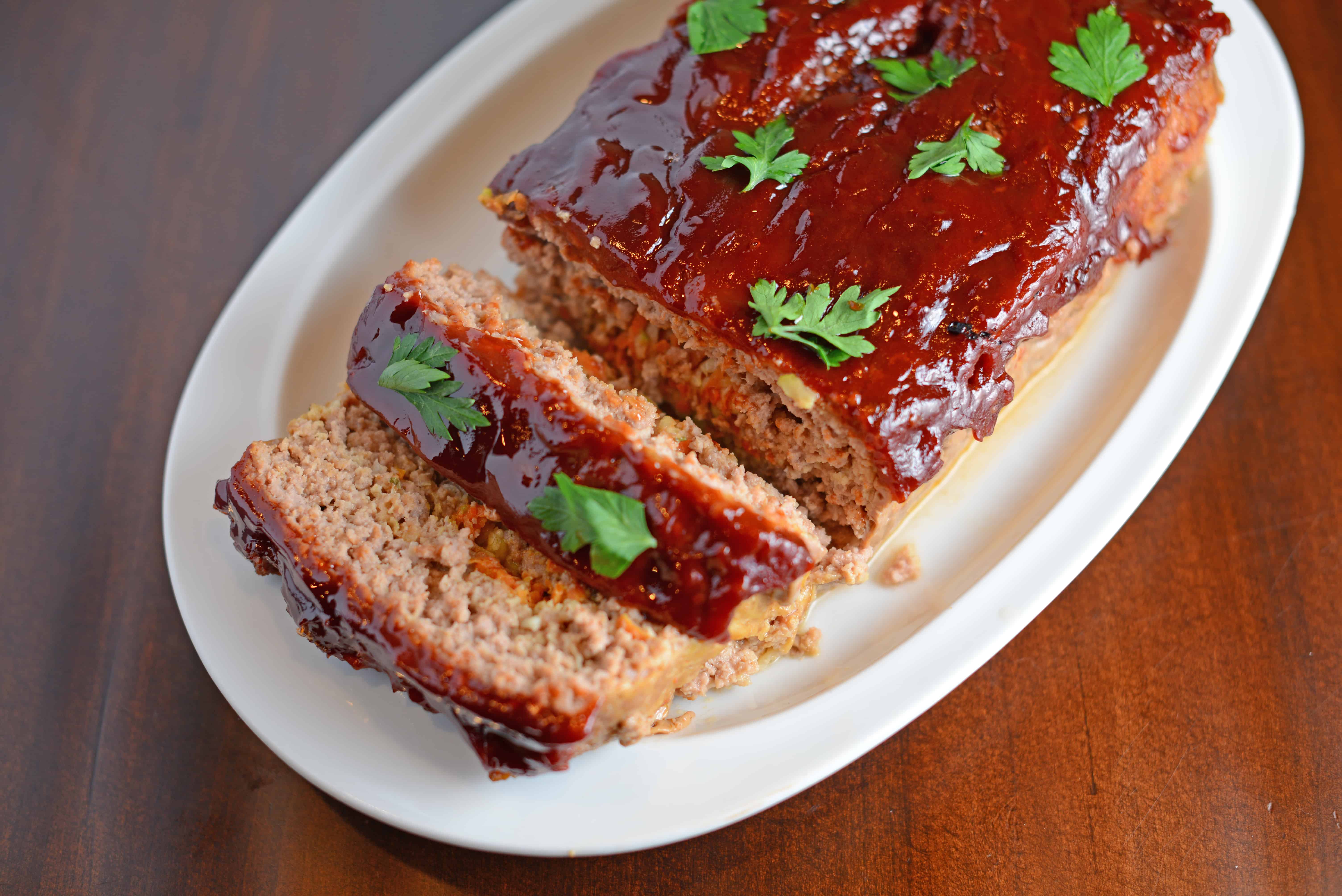 Veggie Stuffed Meatloaf Recipe- The most tender meatloaf ever! Stuffed with carrot and zucchini and topped with a zesty ketchup blend with a special ingredient. Come see what makes this meatloaf one even meatloaf-haters will LOVE! www.savoryexperiments.com