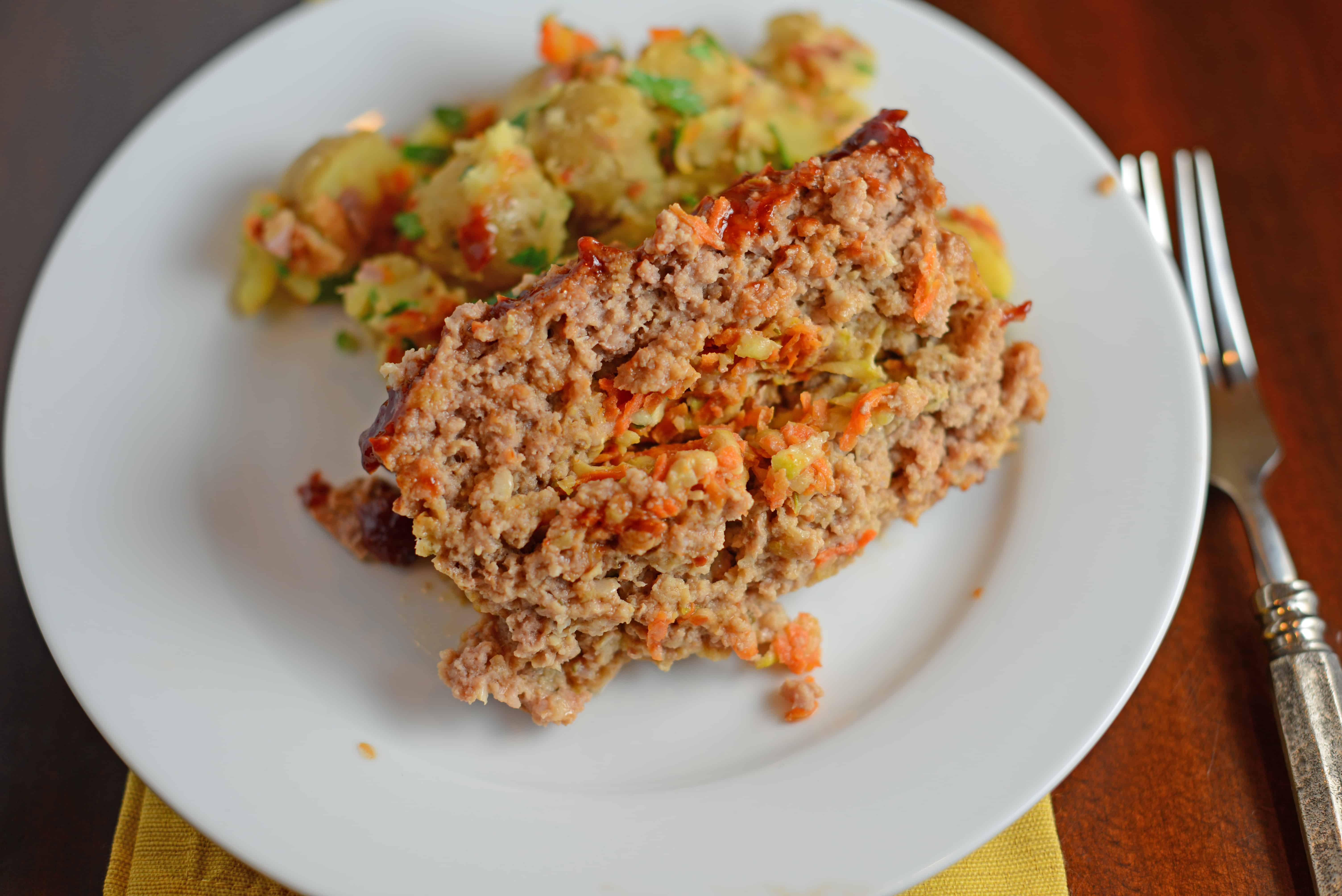Veggie Stuffed Meatloaf Recipe- The most tender meatloaf ever! Stuffed with carrot and zucchini and topped with a zesty ketchup blend with a special ingredient. Come see what makes this meatloaf one even meatloaf-haters will LOVE! www.savoryexperiments.com