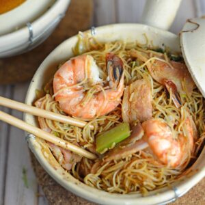 Thai Shrimp with Glass Noodles- one pot Thai dish cooked in a clay pot, cast iron or a Dutch oven. Shrimp steam between a layer of bacon and aromatics and glass noodles tossed in spy sauce. Topped with a zesty Thai sauce and fresh greens. Also known as Kung Op Wun Sen.