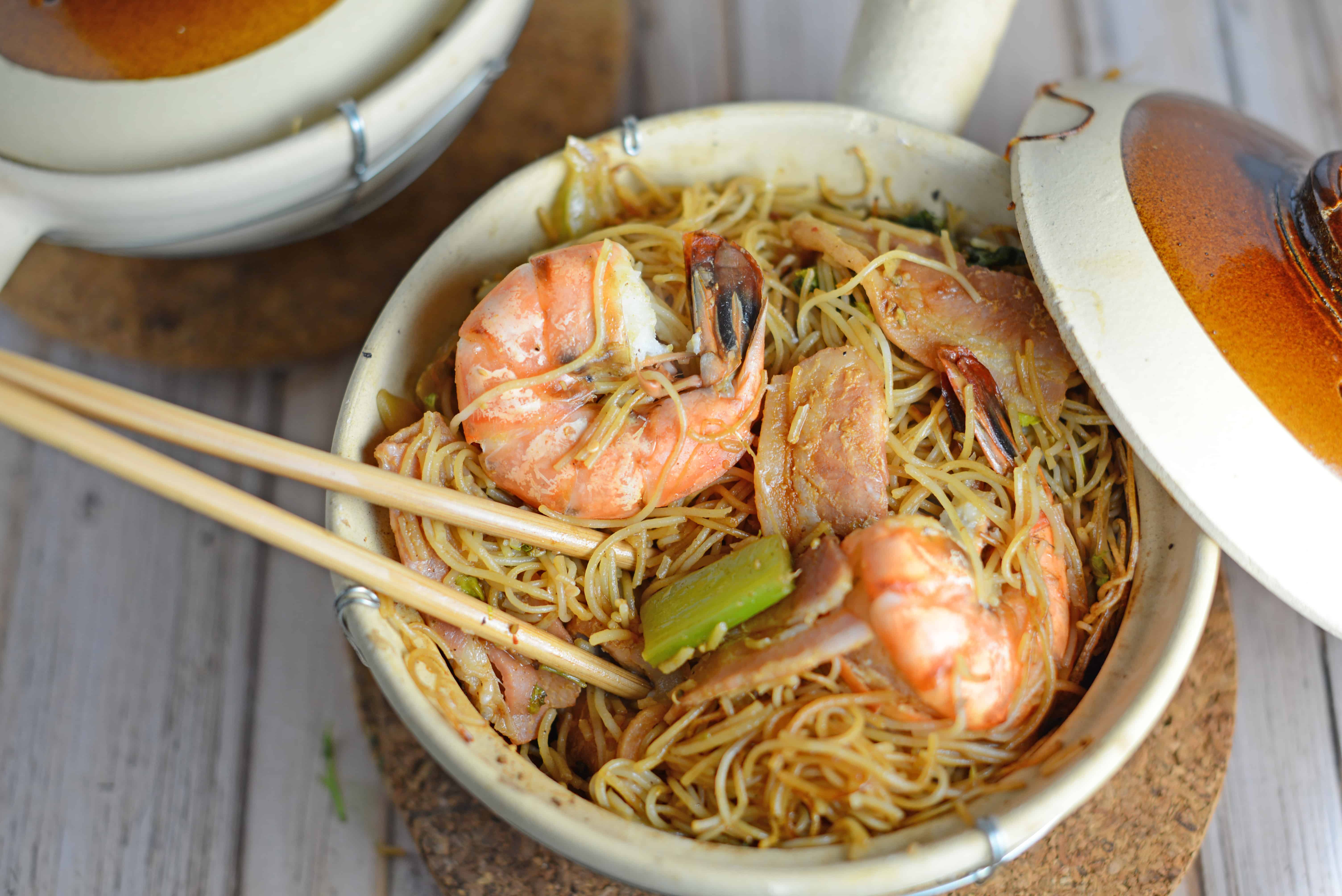 Thai Shrimp with Glass Noodles- one pot Thai dish cooked in a clay pot, cast iron or a Dutch oven. Shrimp steam between a layer of bacon and aromatics and glass noodles tossed in spy sauce. Topped with a zesty Thai sauce and fresh greens. Also known as Kung Op Wun Sen.