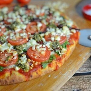 Tomato and Pesto Pizza Recipe - The BEST Homemade Pizza! This is vegetarian and super easy, using 2 types of tomatoes, pesto, mozzarella and feta cheese and toasted pine nuts. Made in a standard kitchen oven! www.savoryexperiments.com