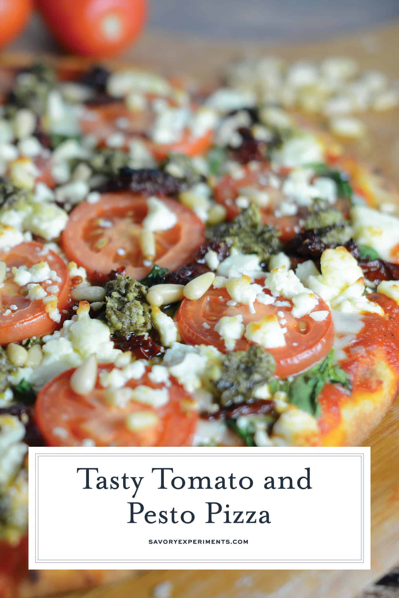 Tomato Pesto Pizza is an easy vegetarian pizza with fresh tomato slices, mozzarella and feta cheese, sun dried tomatoes, pesto and toasted pine nuts. #homemadepizza #pizzafromscratch #pestopizza www.savoryexperiments.com
