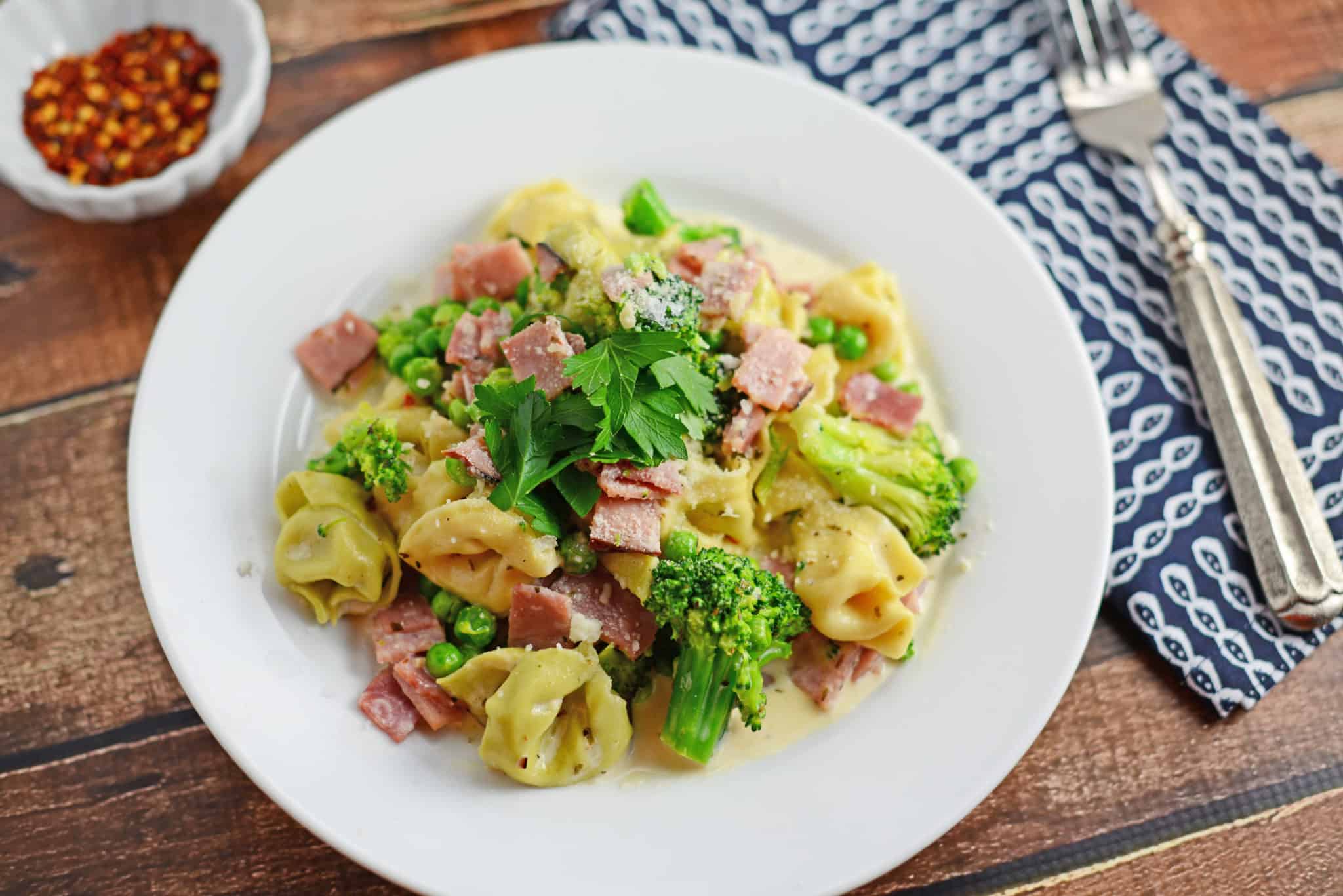 Creamy Tortellini and Ham Pasta - An easy pasta recipe ready in just 20 minutes! Peas, broccoli, ham and cheese tortellini! www.savoryexperiments.com