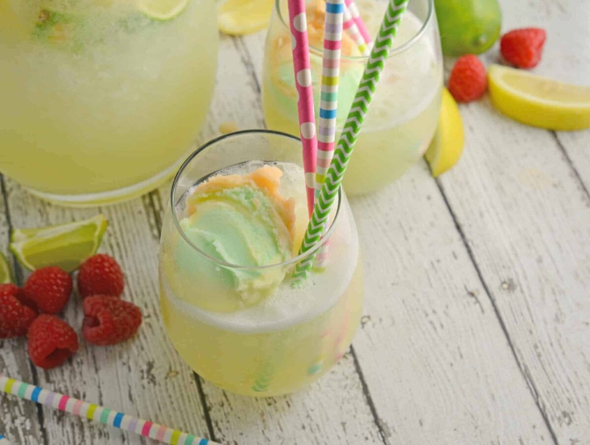 Frozen Limeade Sherbet Floats- a refreshing summer drink perfect for parties and BBQs! Cool limeade blended with ice and topped with a heaping scoop of rainbow sherbet! Perfect for kids, but an adult option available. www.savoryexperiments.com