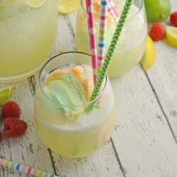 Frozen Limeade Sherbet Floats- a refreshing summer drink perfect for parties and BBQs! Cool limeade blended with ice and topped with a heaping scoop of rainbow sherbet! Perfect for kids, but an adult option available. www.savoryexperiments.com