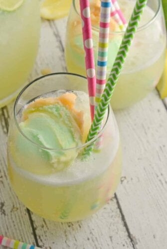 Frozen Limeade Sherbet Floats- a refreshing summer drink perfect for parties and BBQs! Cool limeade blended with ice and topped with a heaping scoop of rainbow sherbet! Perfect for kids, but an adult option available. www.savoryexperiments.com