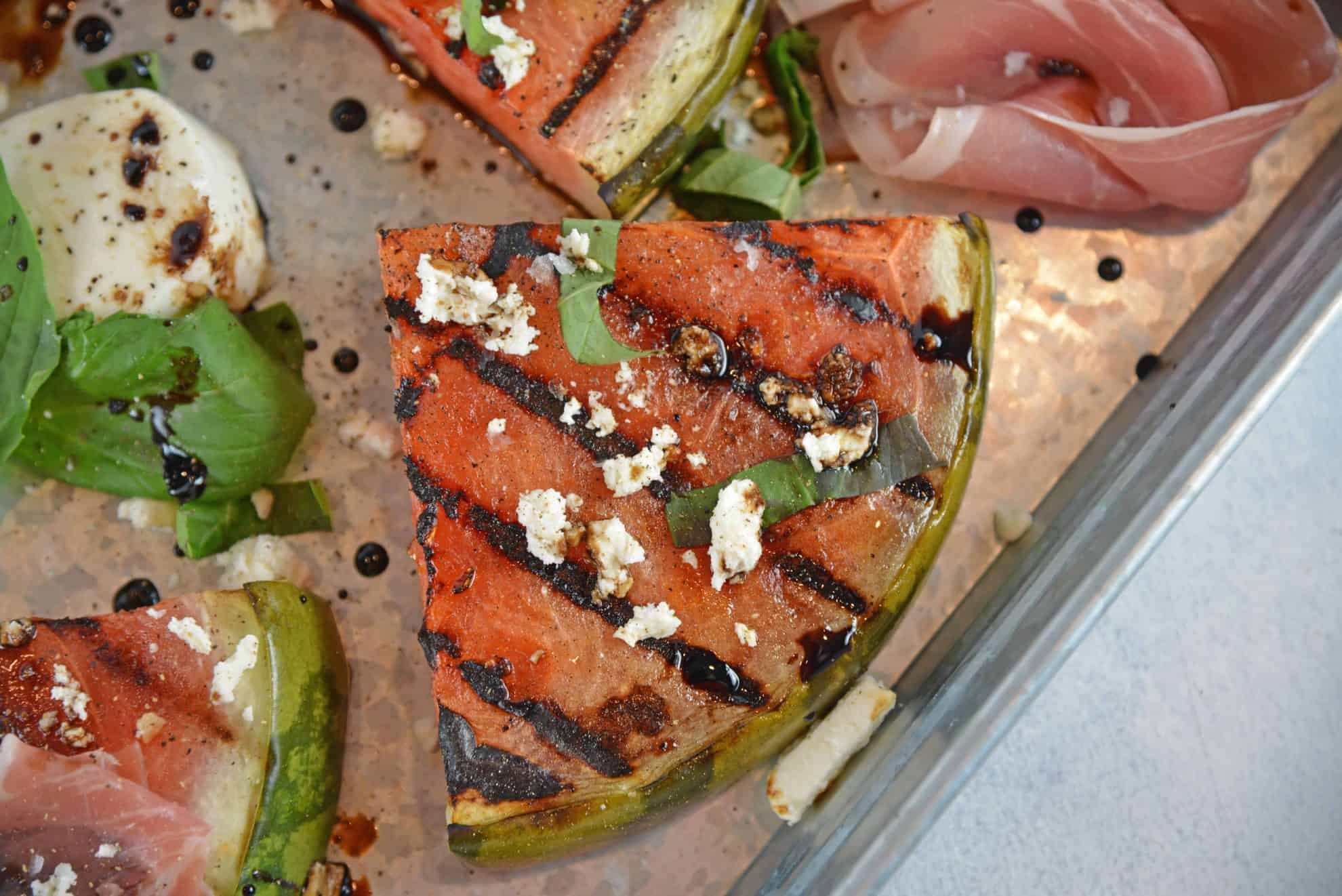 Grilled Watermelon Steaks with balsamic reduction and feta cheese are an easy BBQ side dish. Caramelized, juicy watermelon with savory cheese and sticky reduction is delicious! #grilledwatermelon #watermelonrecipes www.savoryexperiments.com 