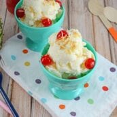 pina colada ice cream in a teal ice cream bowl with cherries