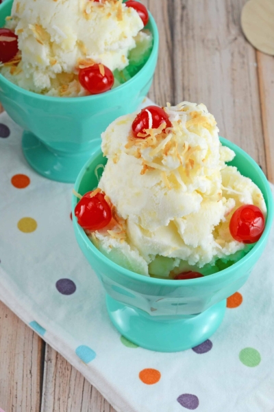 pina colada ice cream in a teal ice cream bowl with cherries