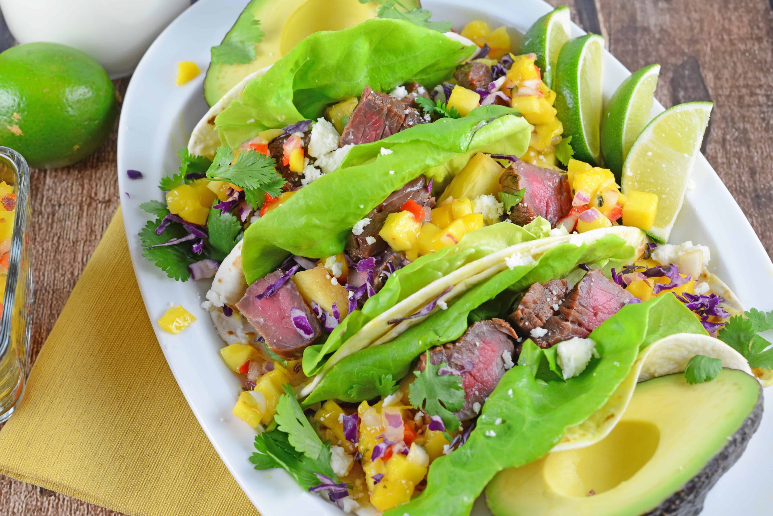 Tropical Beef Tacos Recipe - the secret for interesting and amazing soft tacos! Easy soft tacos with mango salsa, queso fresco and red cabbage. www.savoryexperiments.com