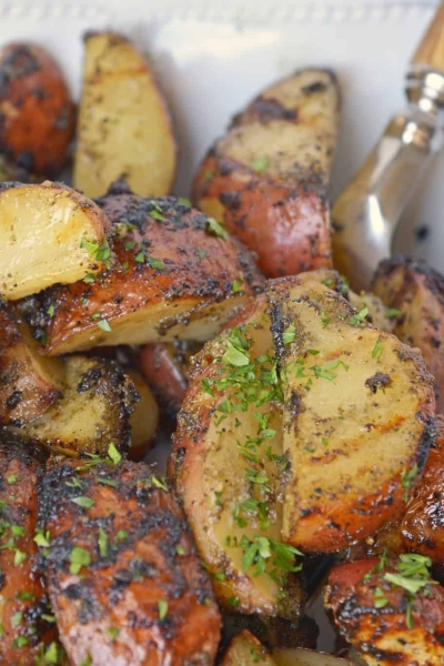 Herb Grilled Potatoes uses miracle whip and a handful of spices to keep those spuds nice and moist with loads of flavor! Make this easy side dish today! #grilledpotatoes #grilledpotatowedges www.savoryexperiments.com