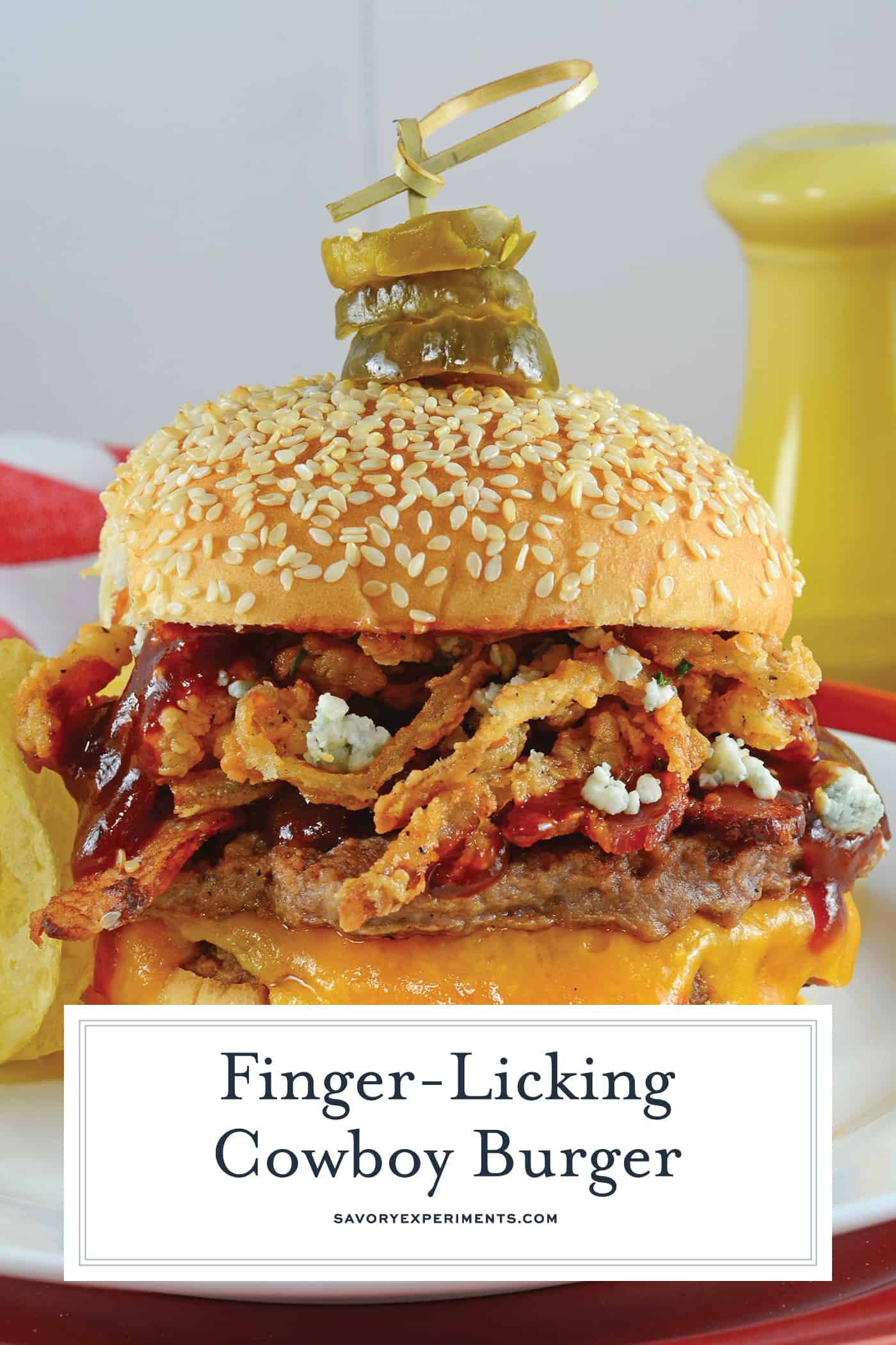 Cowboy Burger is made of double patties with cheddar, blue cheese, onion strings, BBQ sauce, bacon and topped with honey habanero pickles! The best burger! #cowboyburger #grilledhamburgerrecipes #easyhamburgerrecipes www.savoryexperiments.com