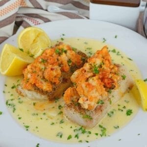 Lobster Stuffed Baked Cod is made from tender buttery cod topped with lumps of lobster meat and beurre blanc sauce! The perfect recipe for a special night! #bakedcod #stuffedcod #bakedcodrecipe www.savoryexperiments.com