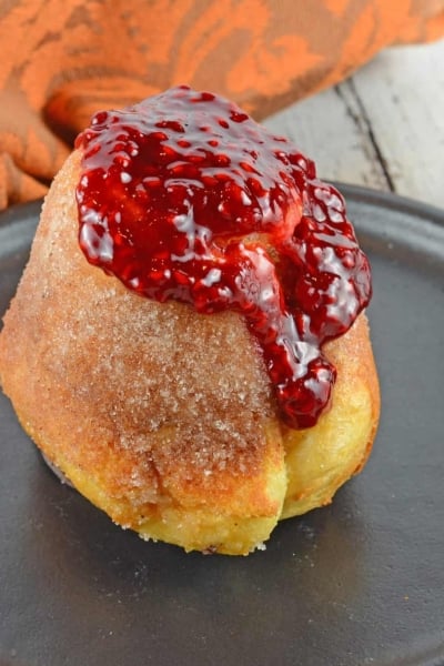 Cinnamon Sugar Popovers are easier to make then you think! A crispy outside and chewy inside coated with cinnamon and sugar, then drizzled in a fresh raspberry sauce.