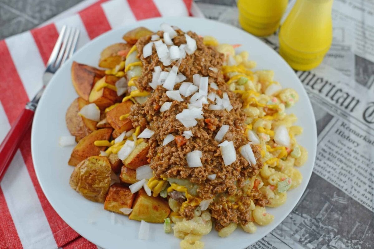 A Garbage Plate is a loaded dish of crispy home fries, hot sauce, macaroni salad and cheeseburgers topped with raw onions, condiments and slices of white bread. #garbageplates www.savoryexperiments.com