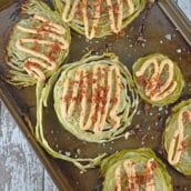 Garlic Cabbage Steaks are caramelized to perfection, then topped with a garlic and smoked paprika aioli, bacon and sea salt. Serve with any meal, especially corned beef! #cabbagerecipes #cabbagesidedish www.savoryexperiments.com
