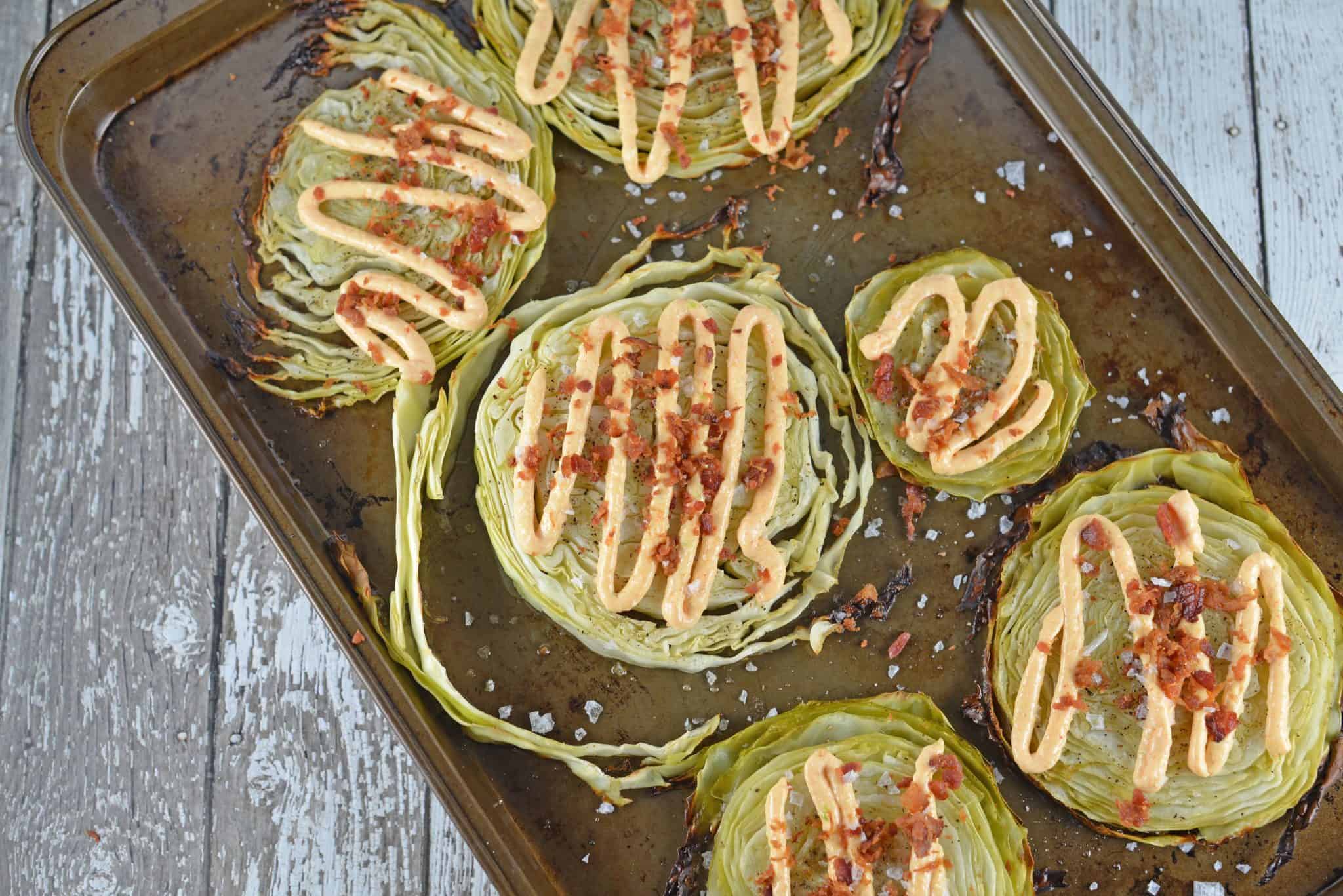 Garlic Cabbage Steaks are caramelized to perfection, then topped with a garlic and smoked paprika aioli, bacon and sea salt. Serve with any meal, especially corned beef! #cabbagerecipes #cabbagesidedish www.savoryexperiments.com 