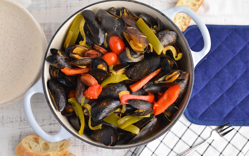 overhead of steamed mussels in a large pot
