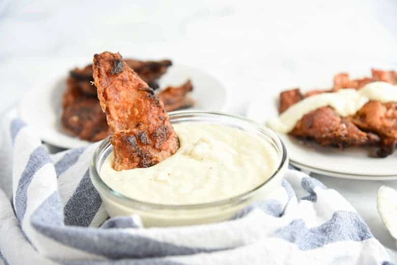 Chicken fried bacon dipping in cream gravy 