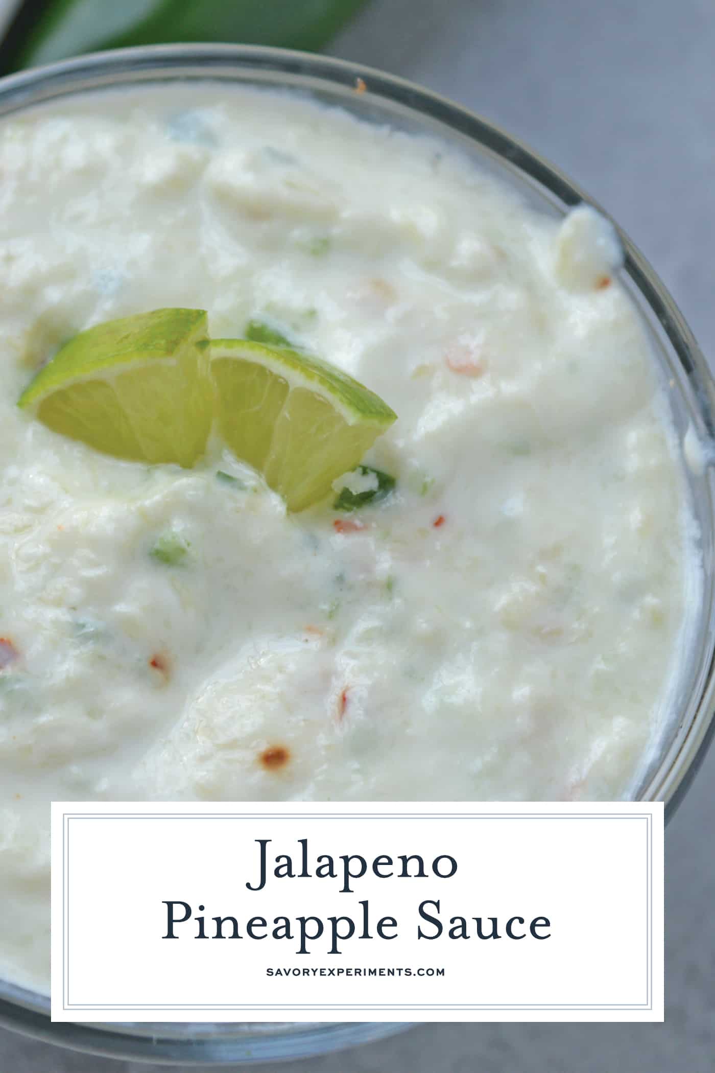 jalapeno pineapple dip in a bowl with two fresh lime wedges