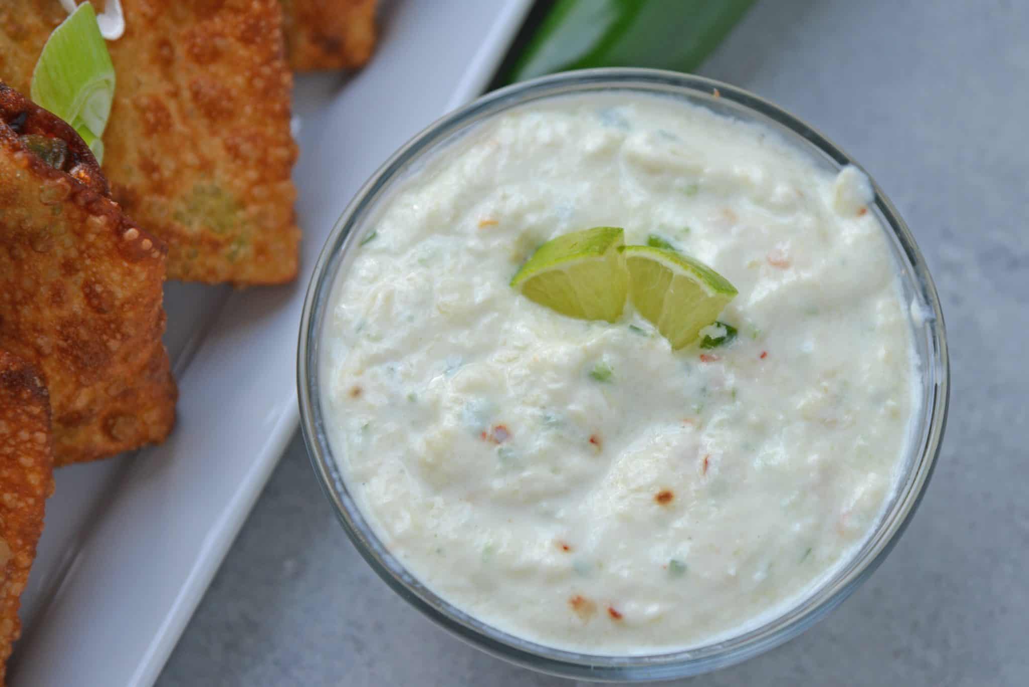 overhead bowl of creamy jalapeno pineapple dip recipe with fresh lime wedges