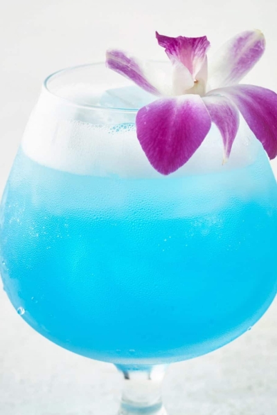 Sparkling Blue Hawaiian Cocktail topped with an orchid